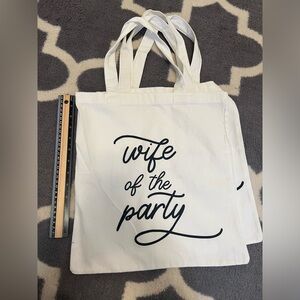 2 brand new white w/ black lettering tote bags! 
willing to sell them separately
